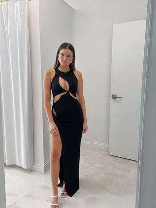 Woman in Mother of All black maxi dress with cutouts