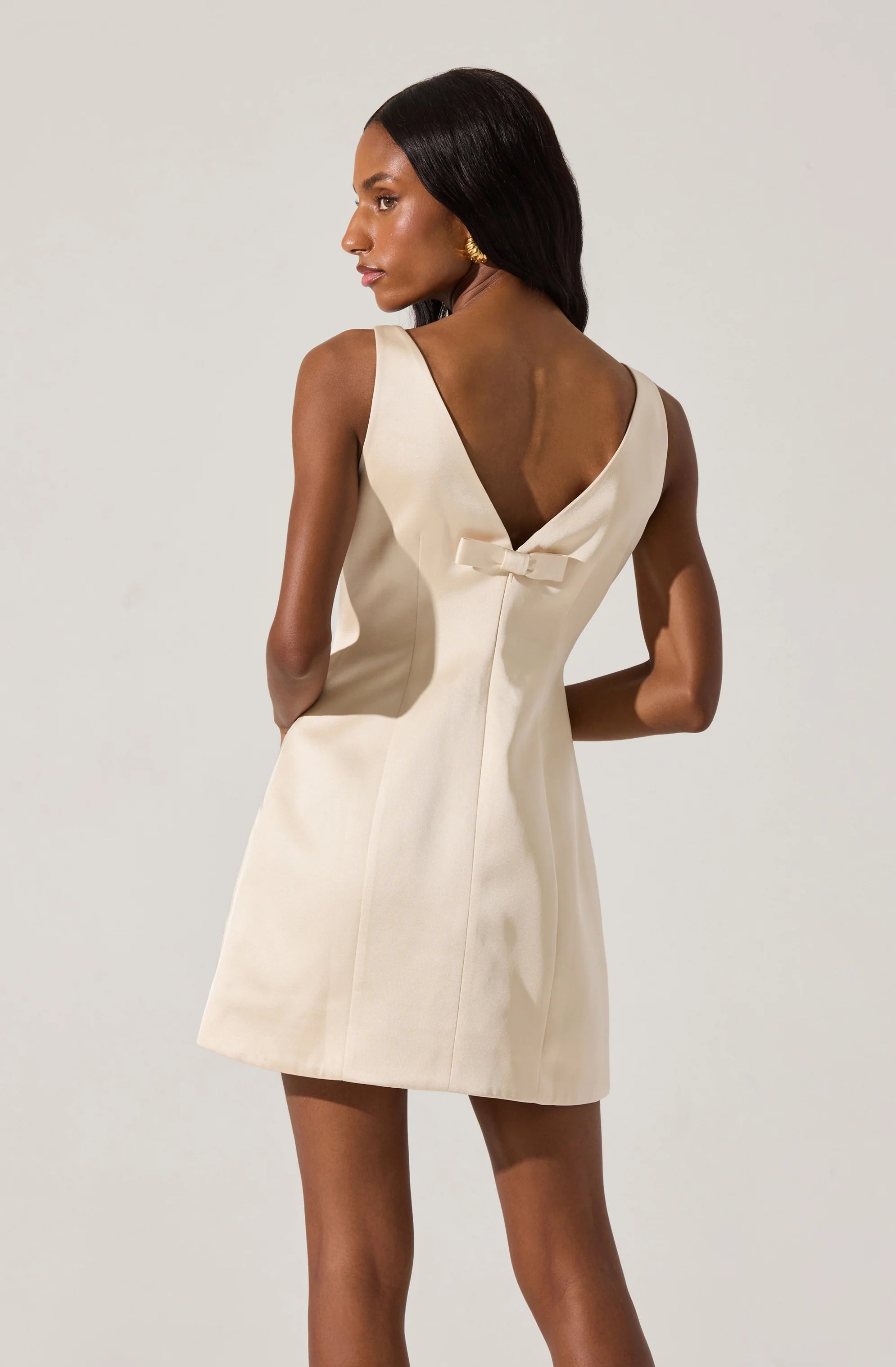 alisanne satin mini dress The Alisanne Dress is oh so darling and classy. This satin mini dress features a high neckline with seam details on the font. The deep v at the back is complemented by