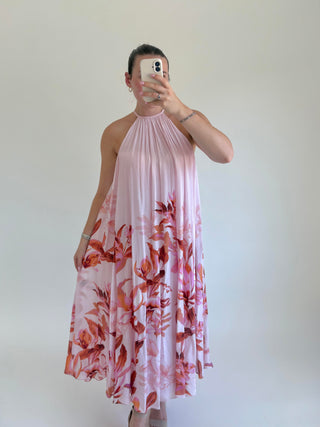 Person wearing a pink floral dress against a plain background